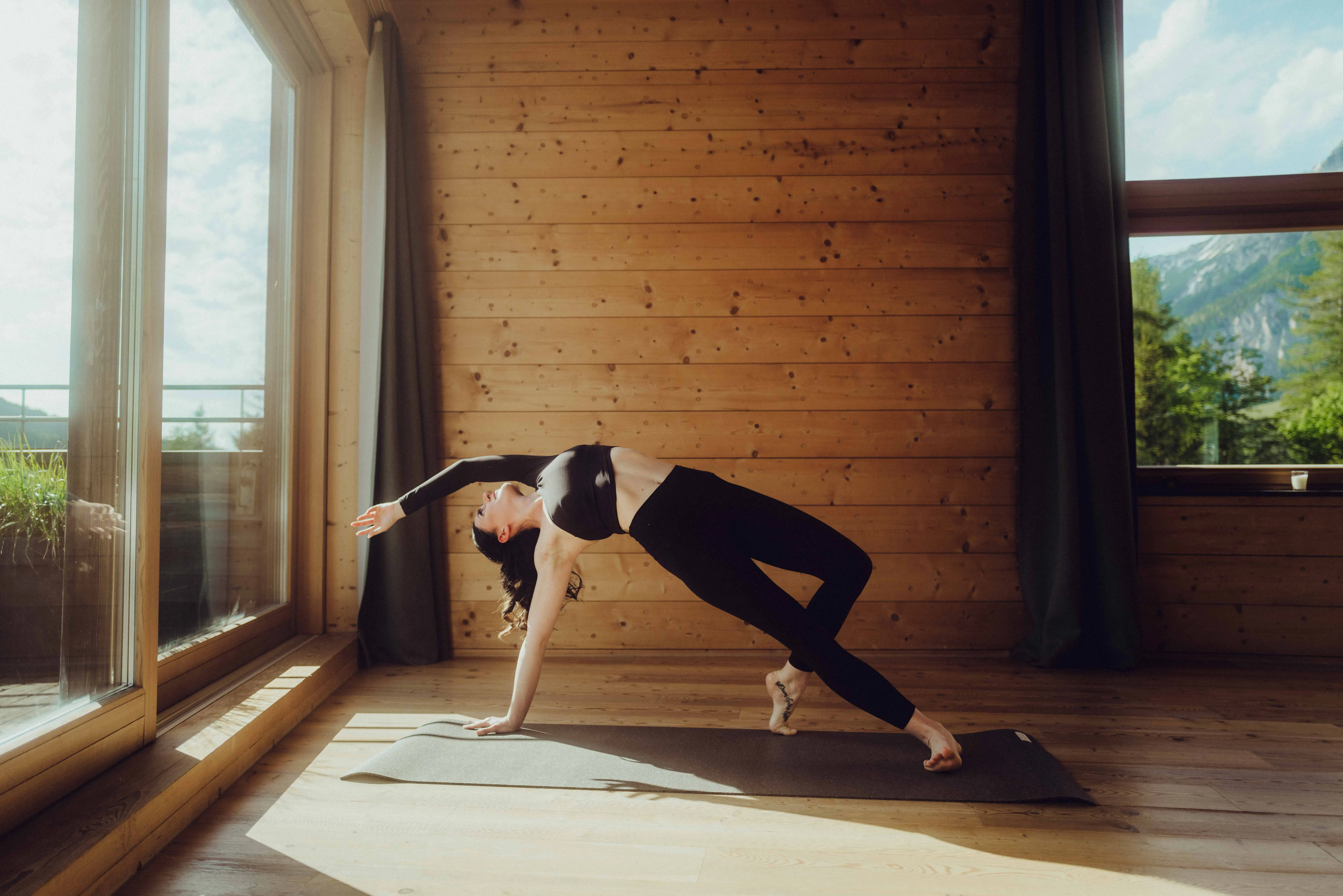 Frau macht Yogapose im Yogaraum aus Holz