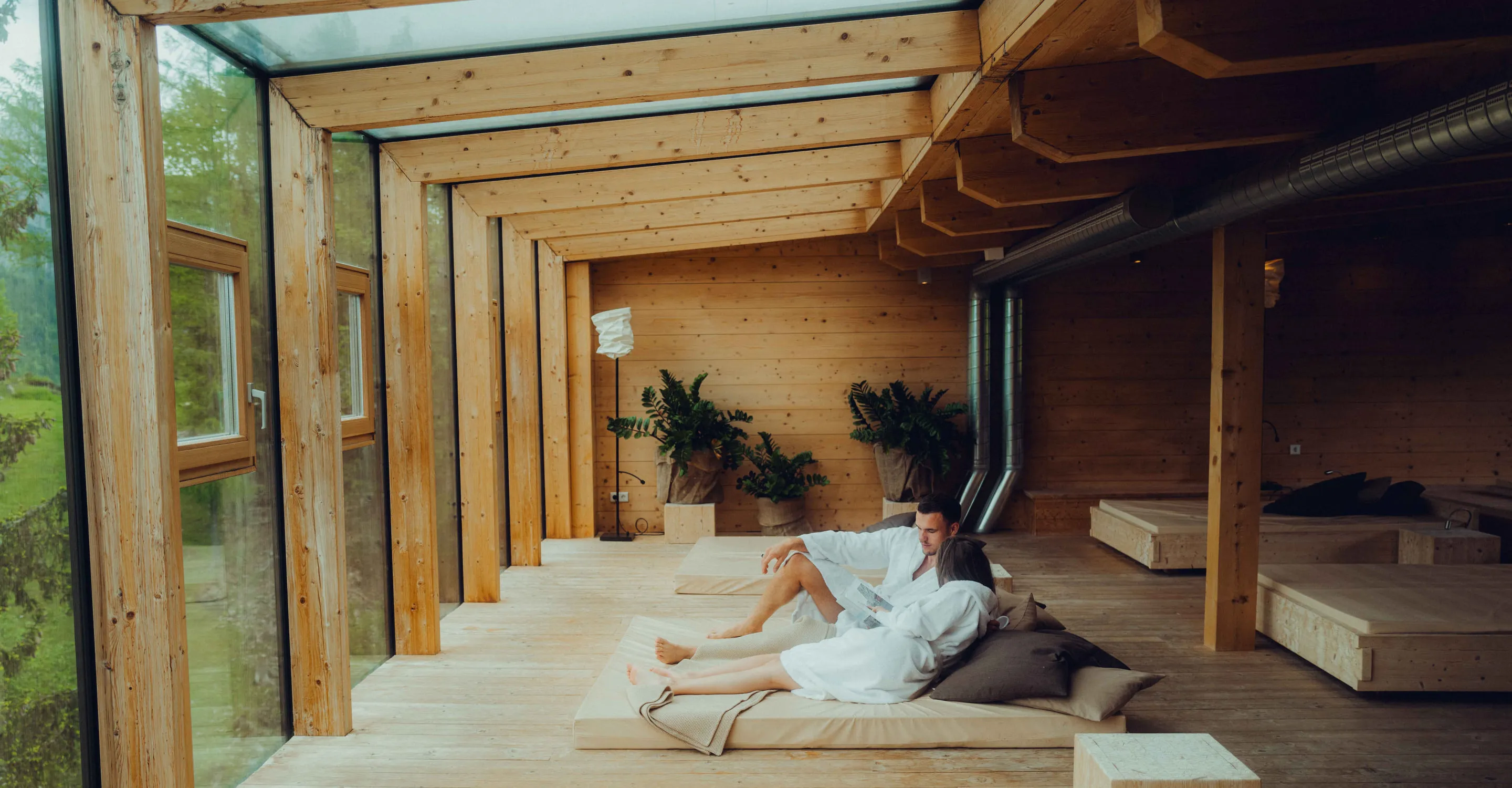 Entspannungsbereich im Holzhotel Forsthofalm, Leogang, mit Holzdekor und Aussicht.