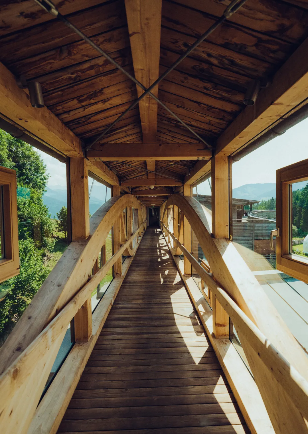 Holzgang mit Bögen und großen Fenstern