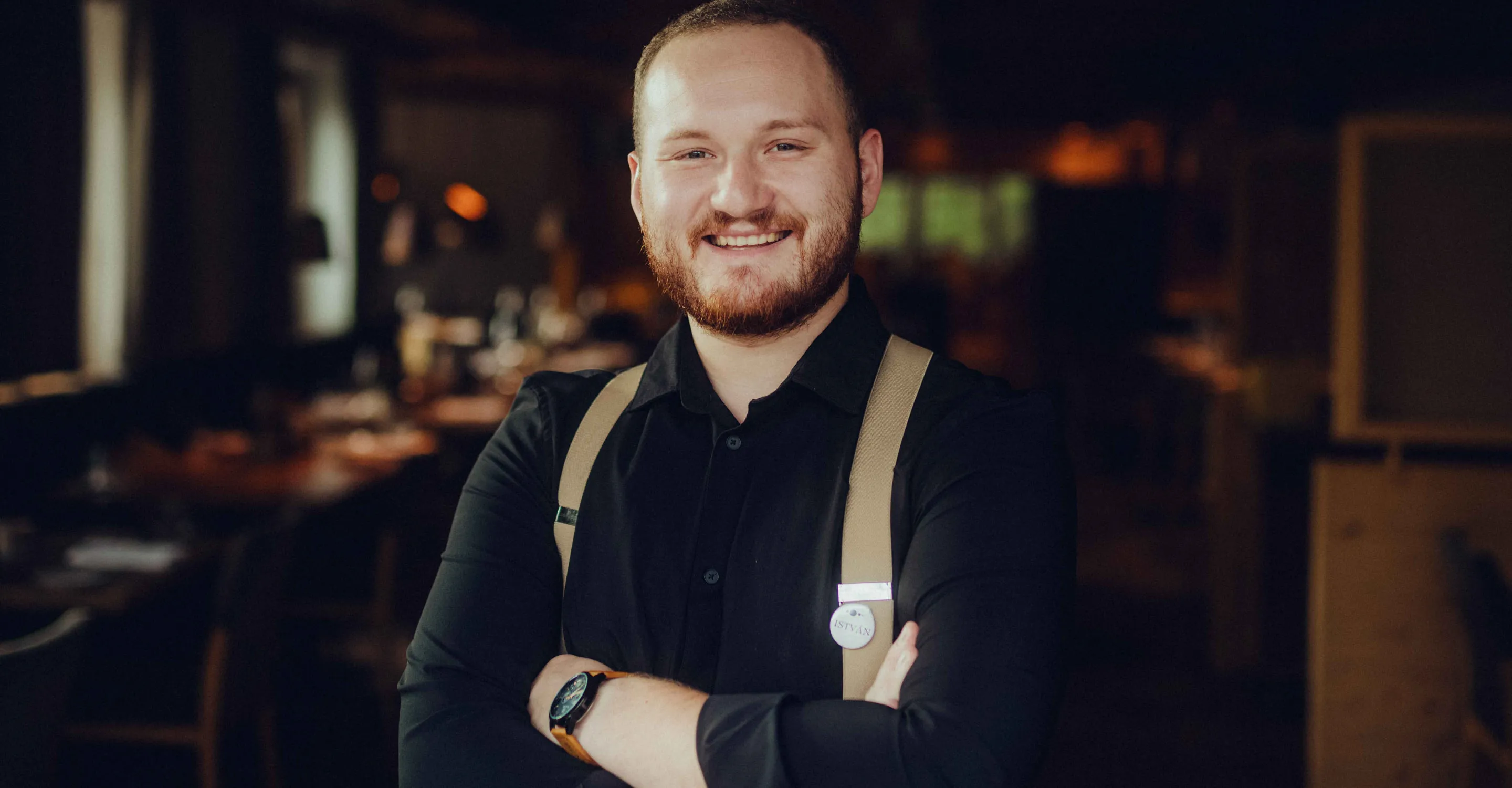 Lächelnder Mann mit Hosenträgern in einem Restaurant