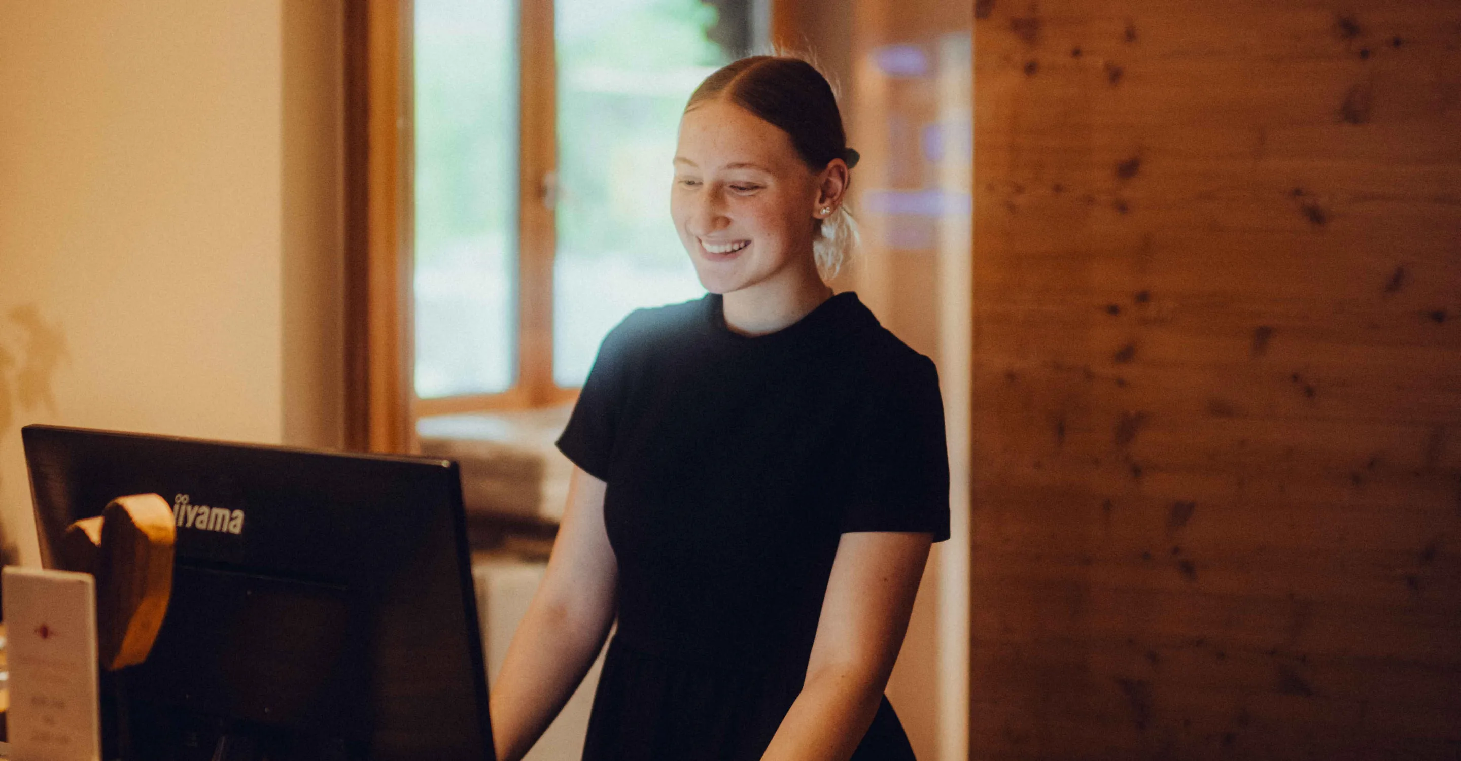 junge Frau lächelt vor einem Computerbildschirm