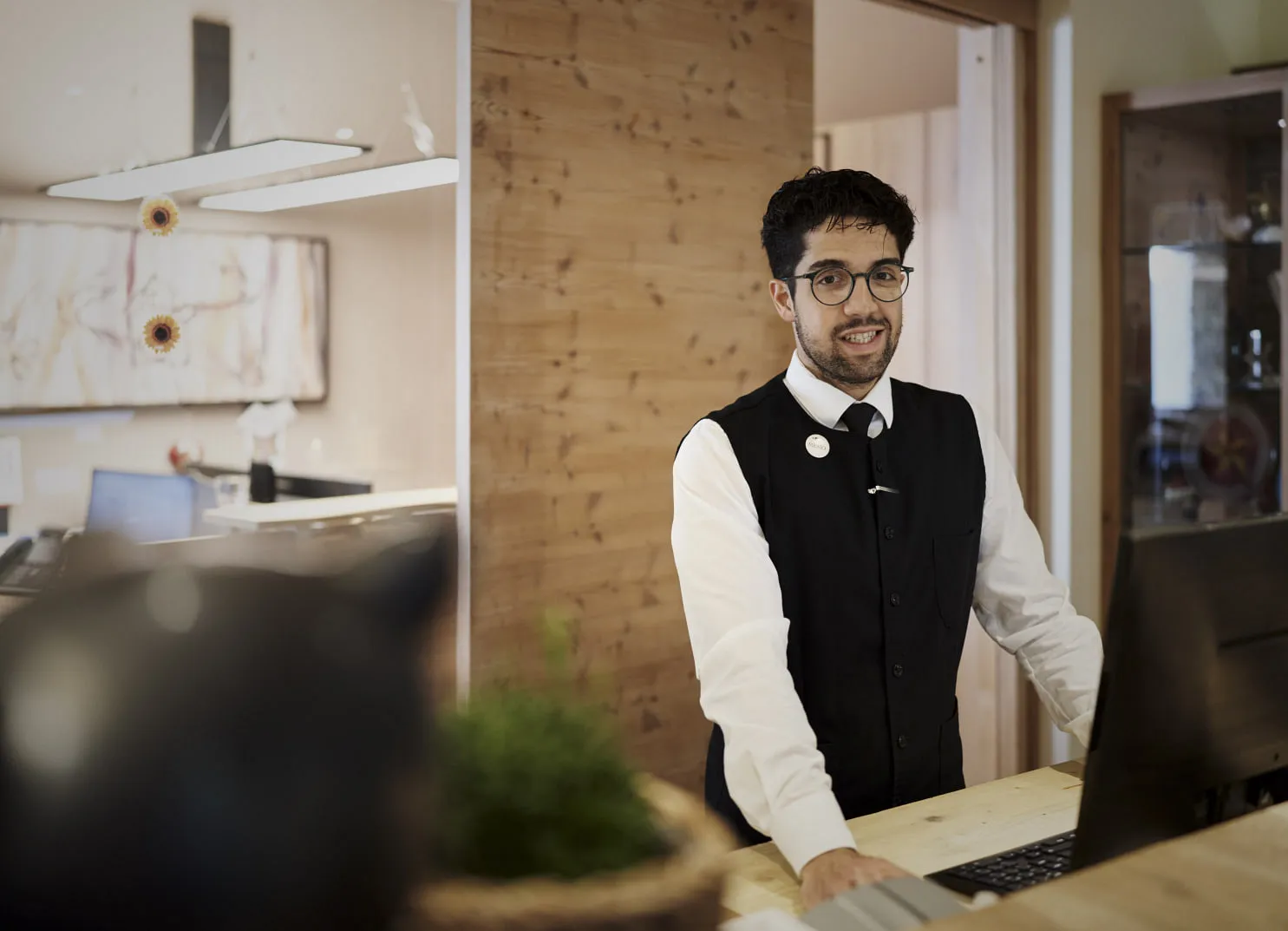 Mann am Empfangstresen mit Computer in einem modernen Büro