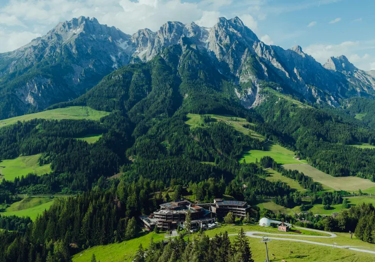 Alpenlandschaft mit Bergen und einem Gebäude im Vordergrund