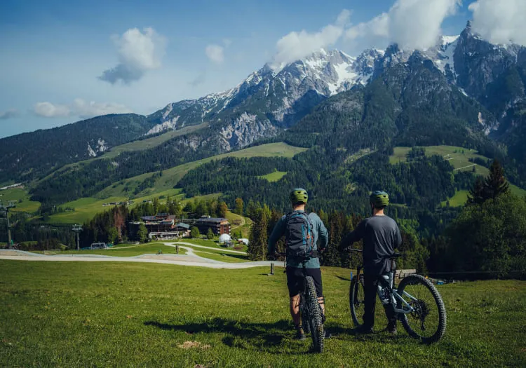 Zwei Radfahrer in alpenreicher Landschaft mit Bergen