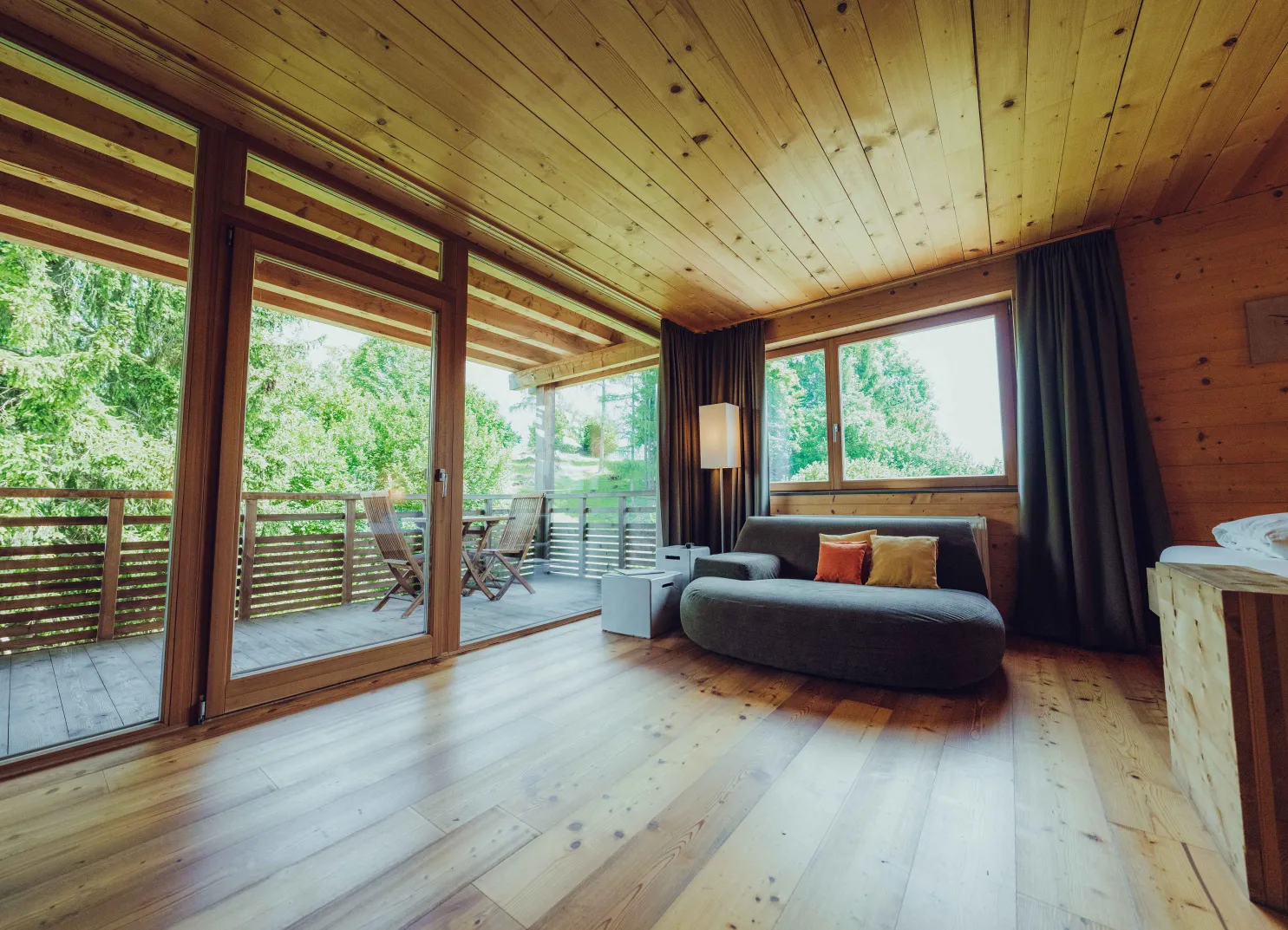 Heller Raum mit Holzdecke, Sofa und Blick auf die Terrasse