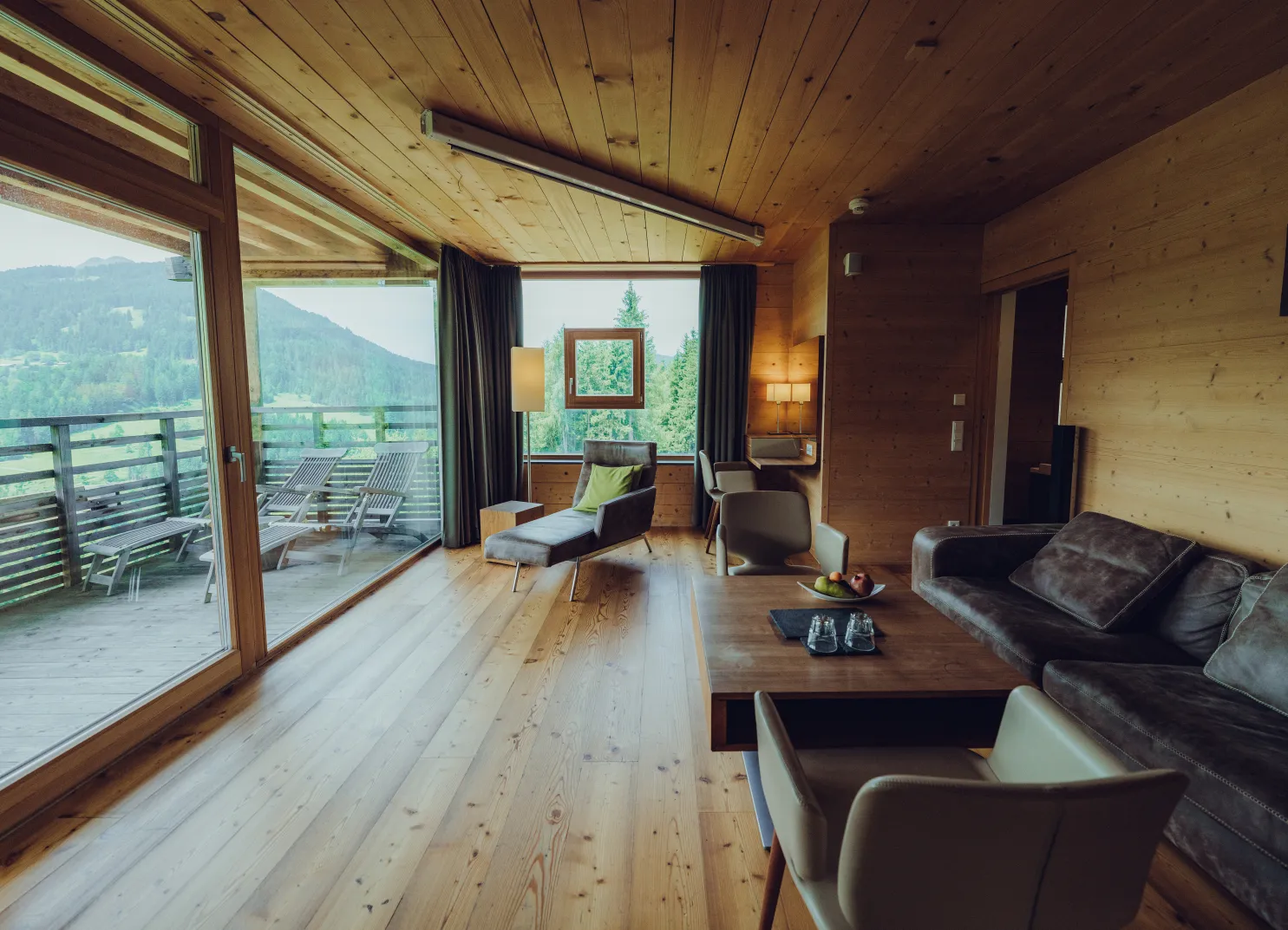 Wood-paneled room with balcony overlooking mountains