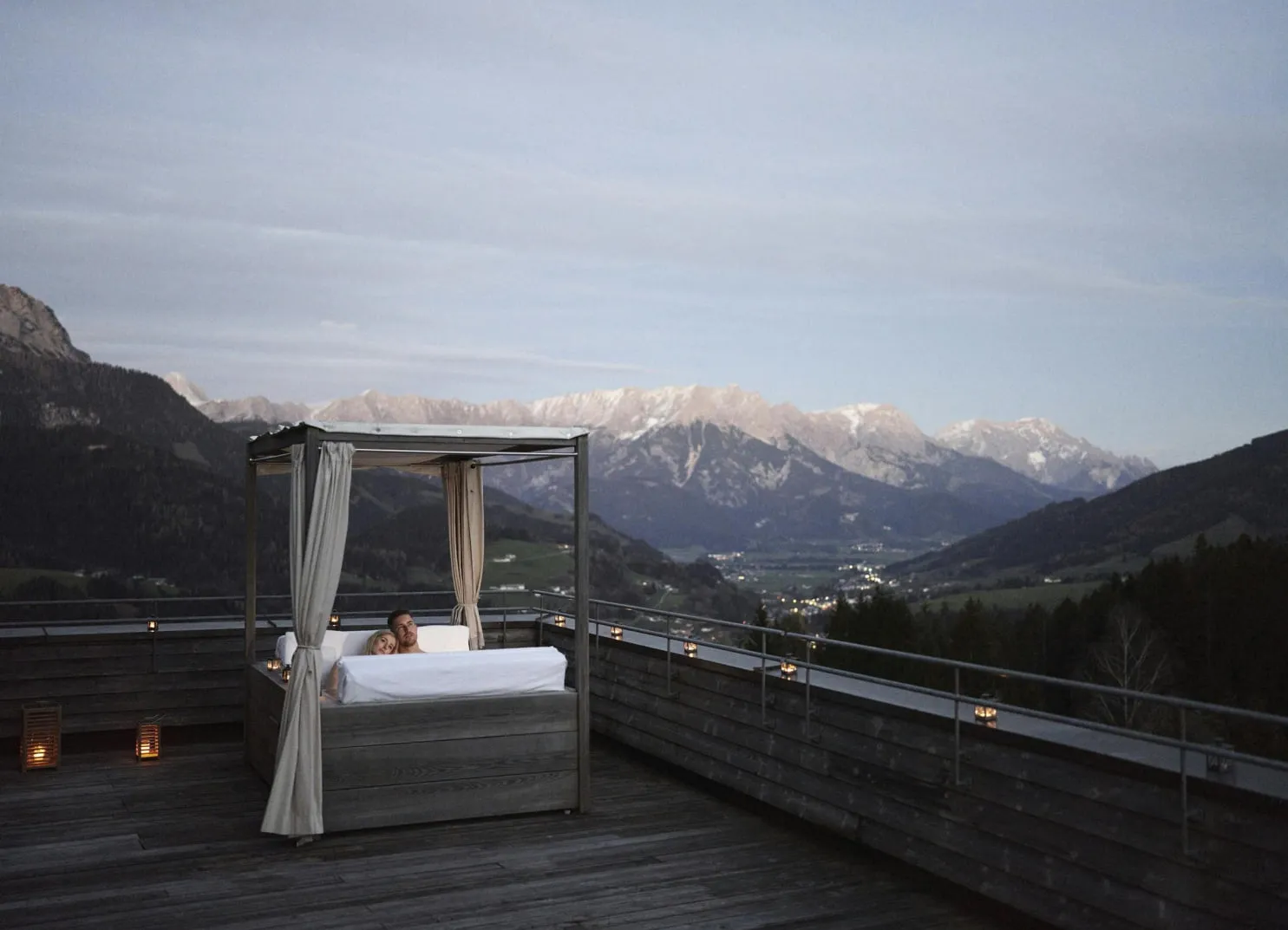 Person entspannt auf einem Terrassenbett mit Bergblick in der Dämmerung