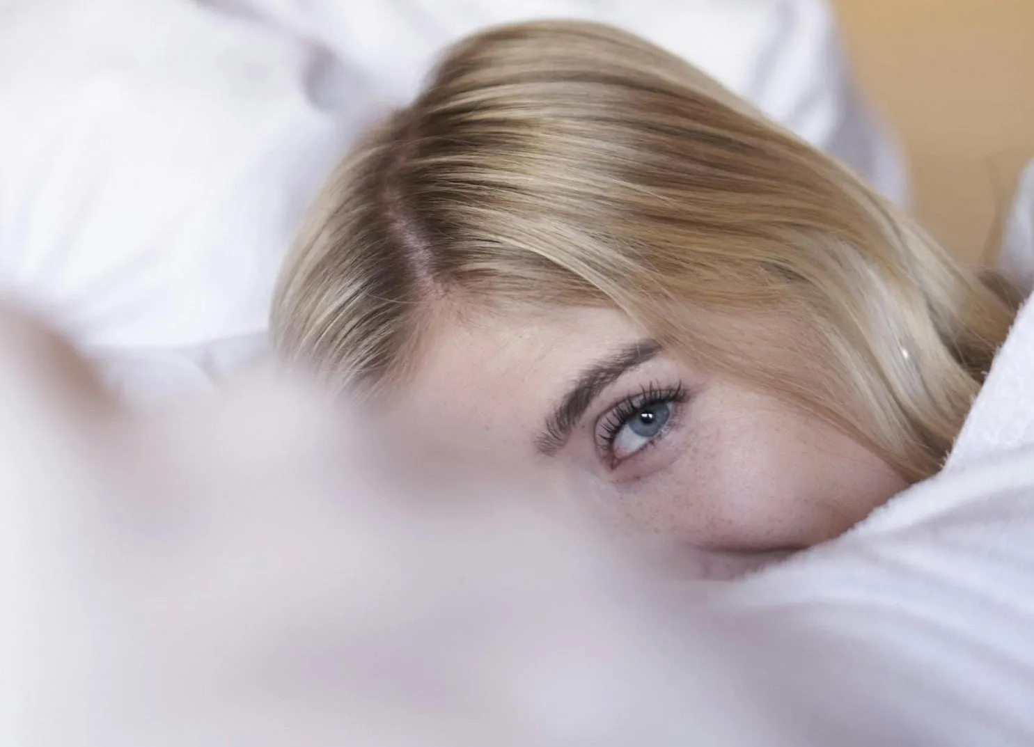 Nahaufnahme eines Teils eines Gesichts mit blonden Haaren und einem blauen Auge.