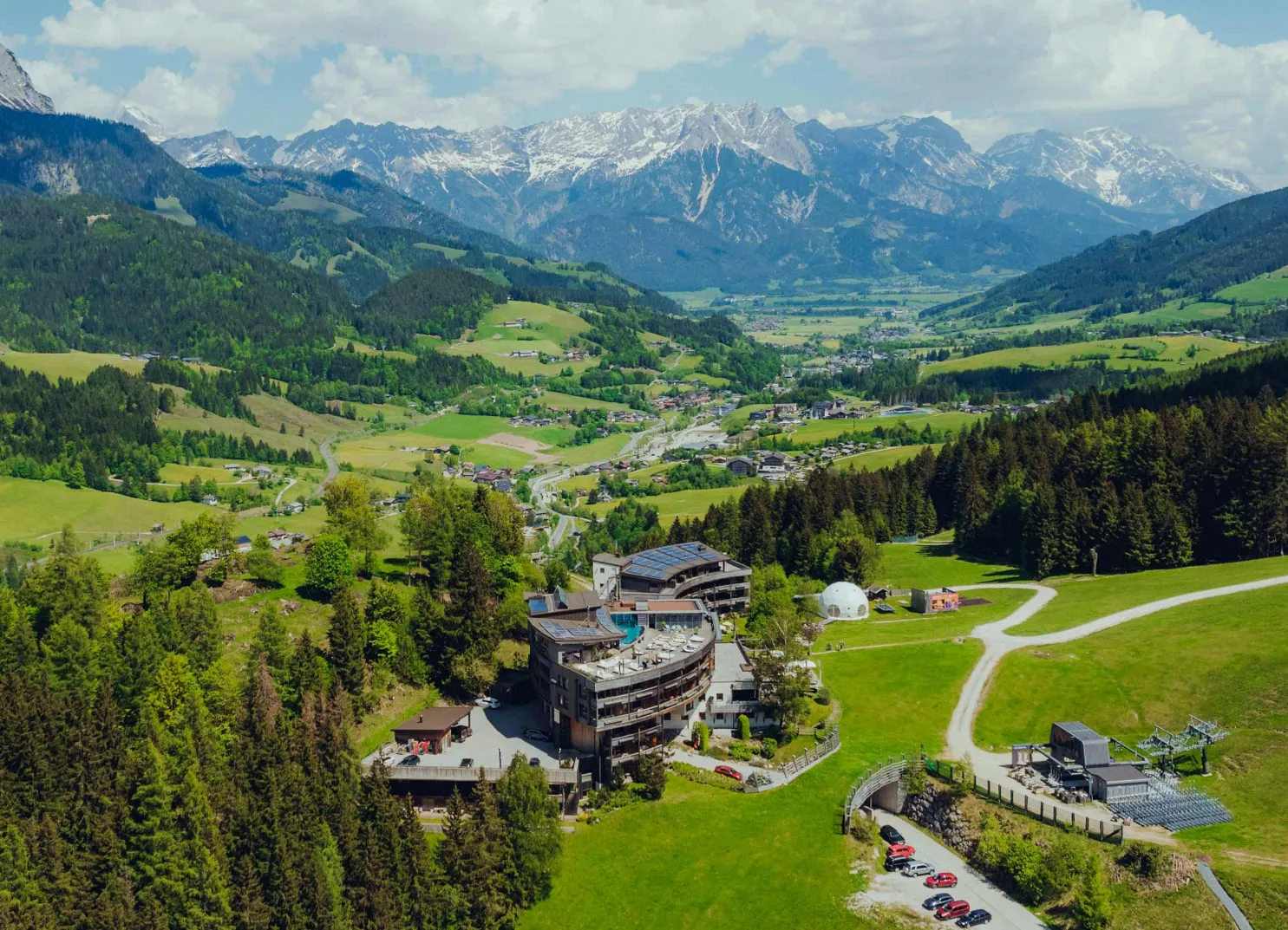 Landschaft mit Bergblick und einem Hotel in den Alpen