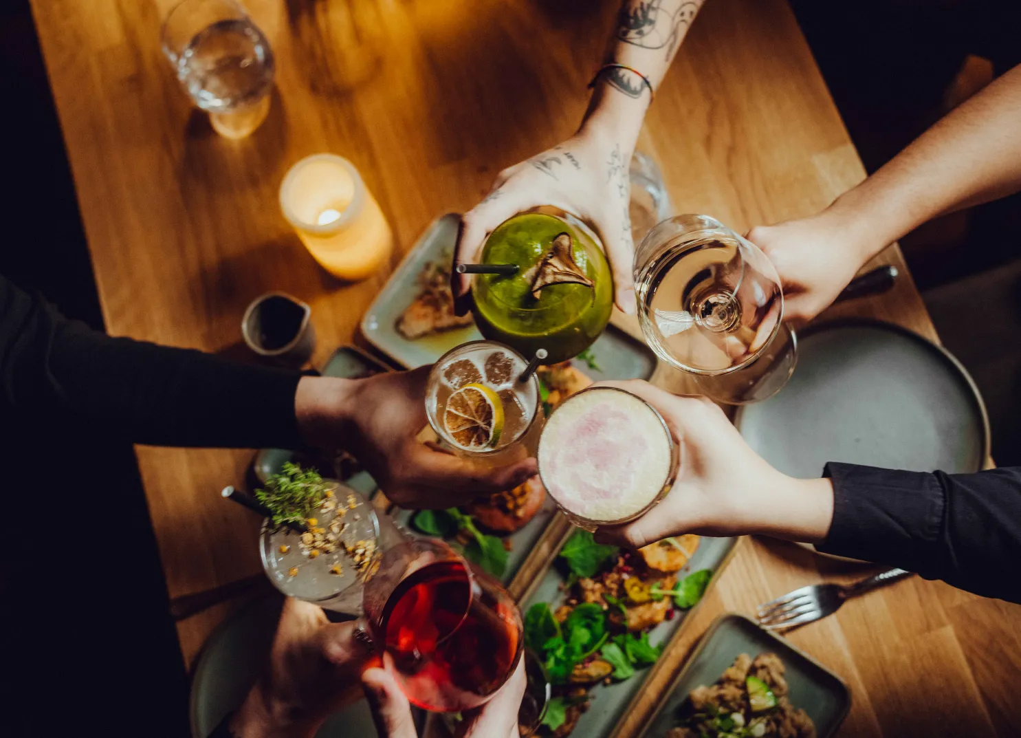 Bunte Cocktails und Essen auf einem Tisch im Holzhotel Forsthofalm