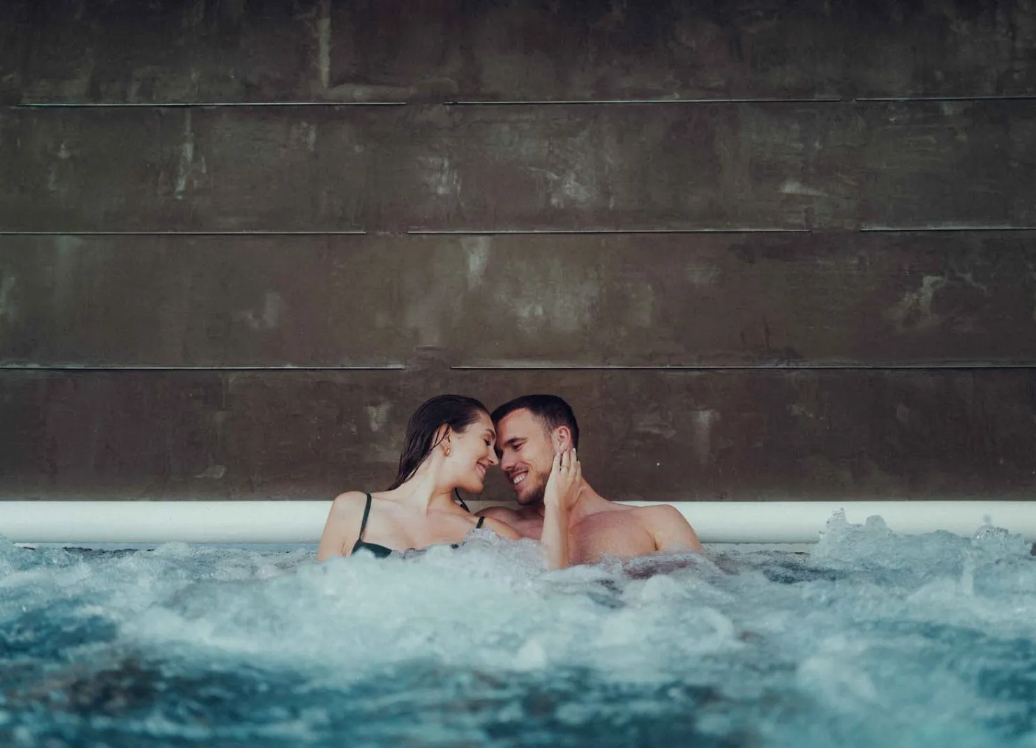 Paar im Pool, nah aneinander, entspannte Atmosphäre