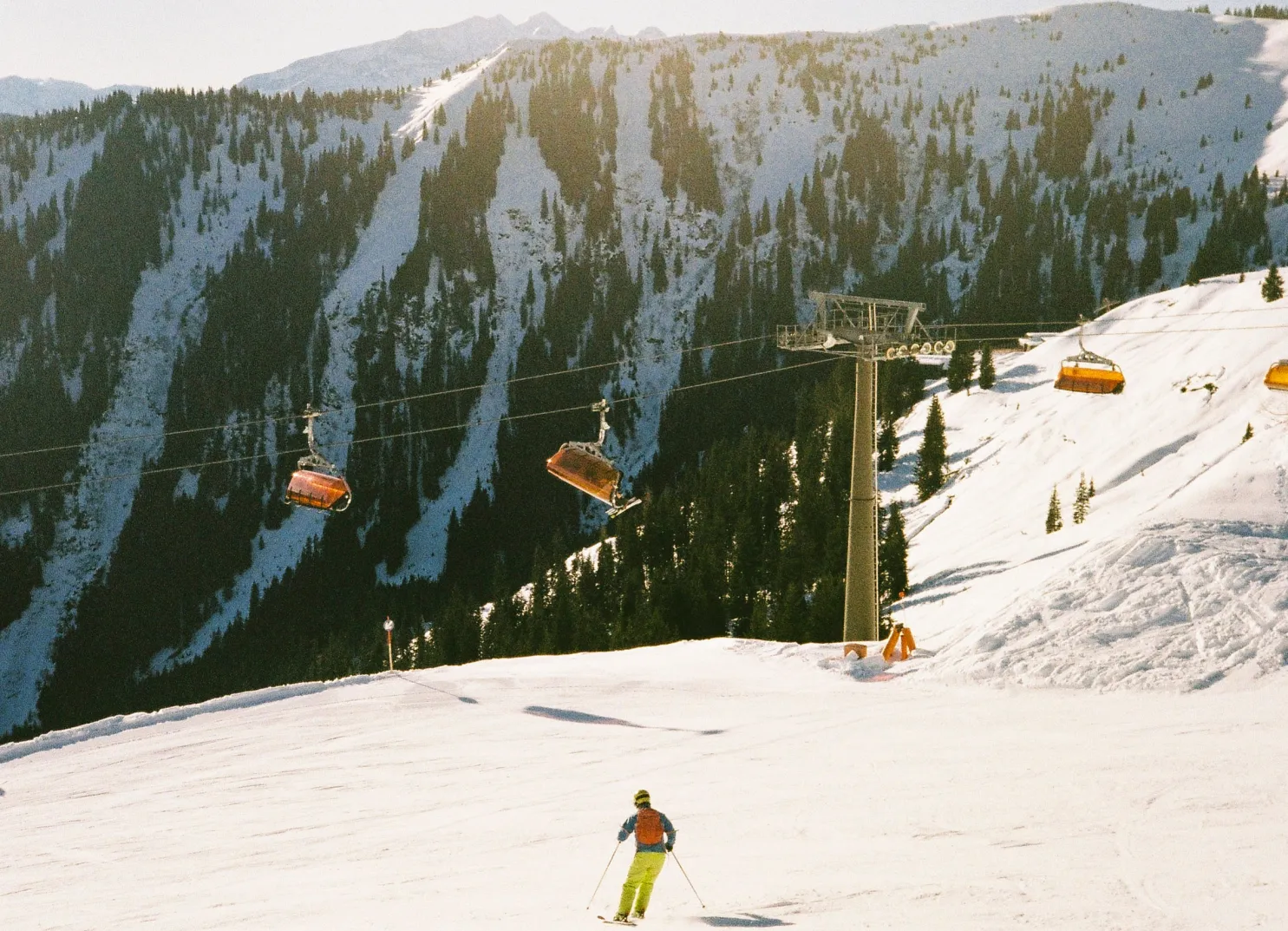 Skifahrer auf einer verschneiten Piste in Leogang mit Lift im Hintergrund