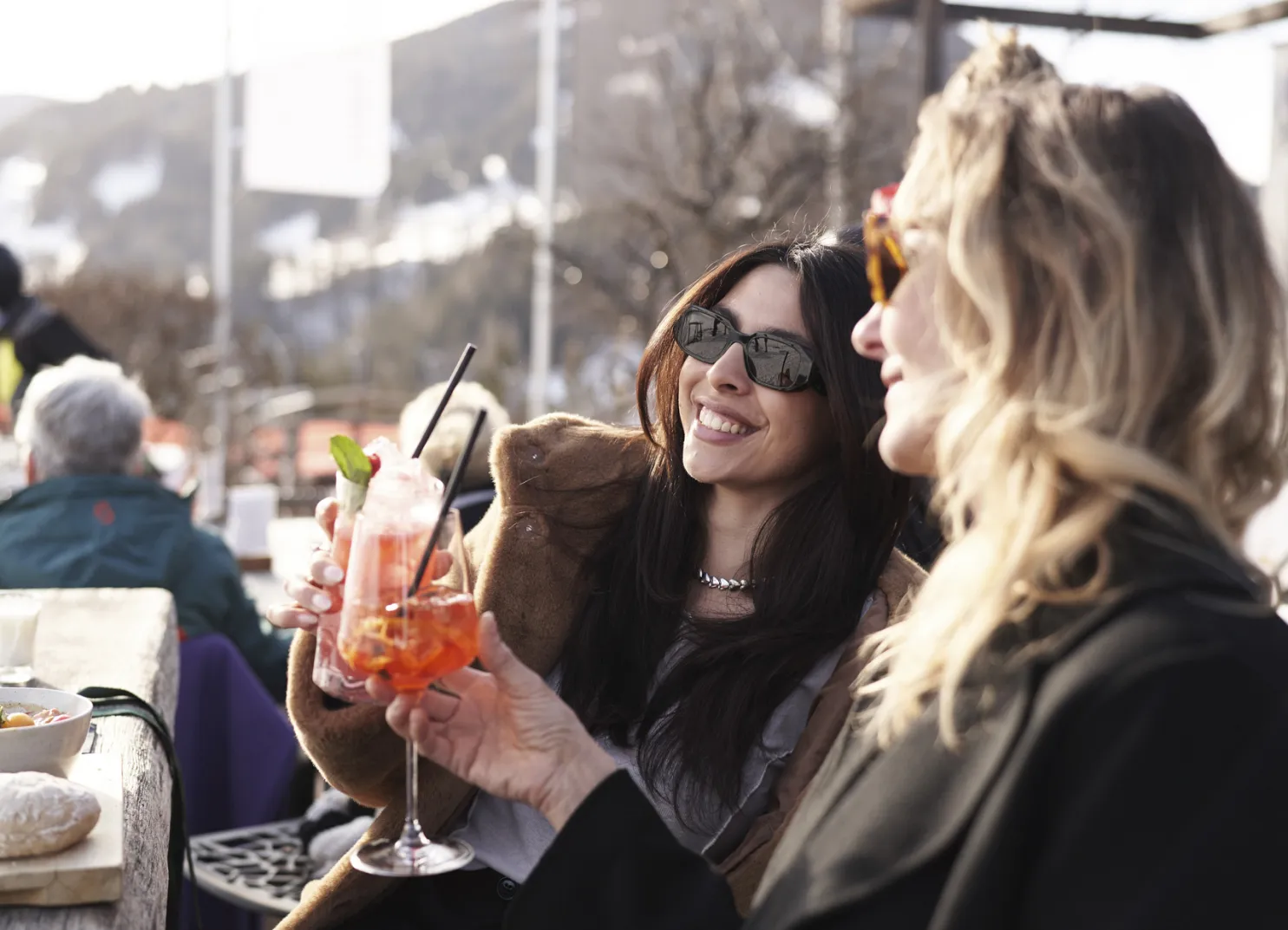 Zwei Frauen mit Cocktails im Holzhotel Forsthofalm in Leogang.