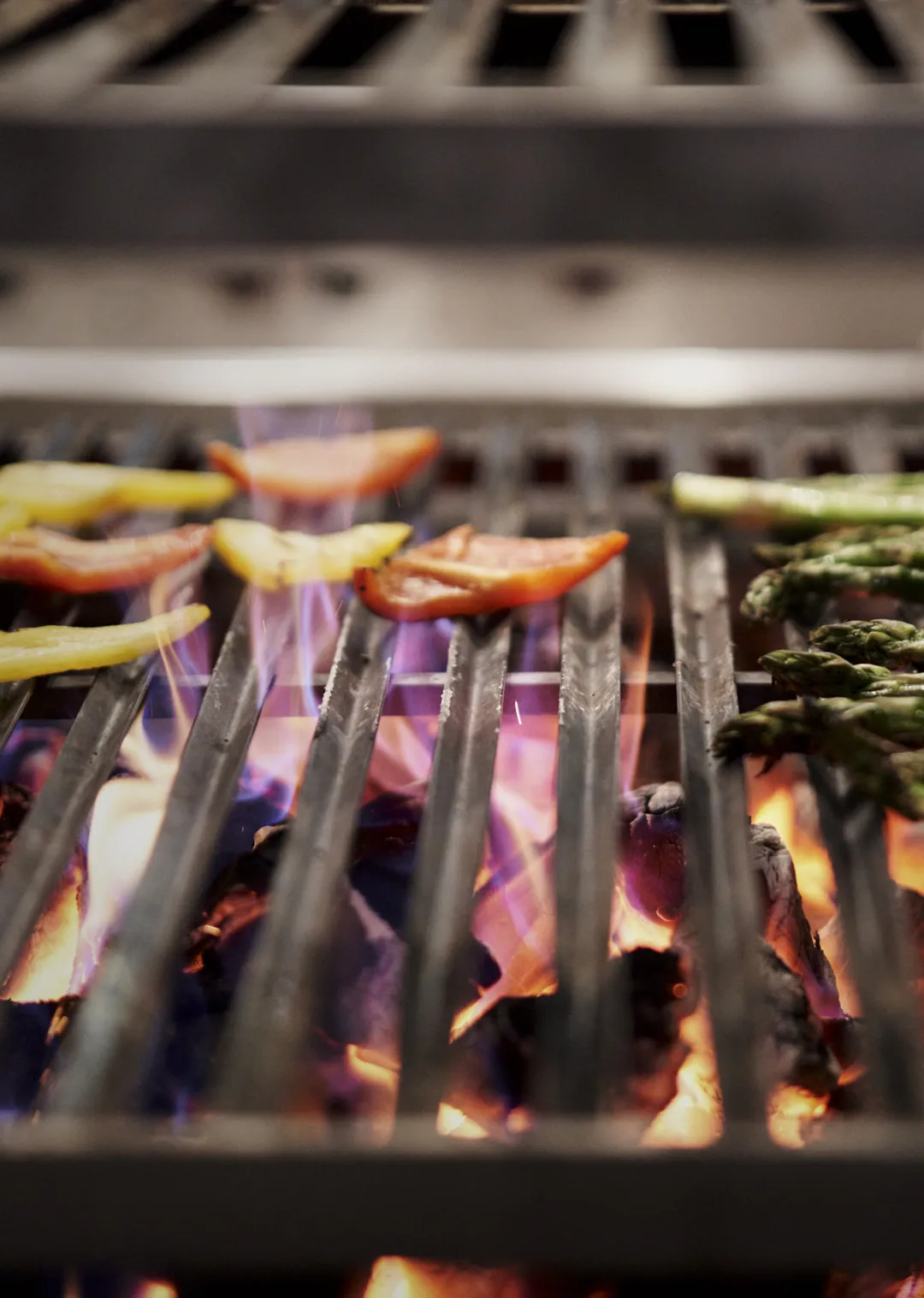 Gegrilltes Gemüse auf einem Holzofen-Grill mit Flammen