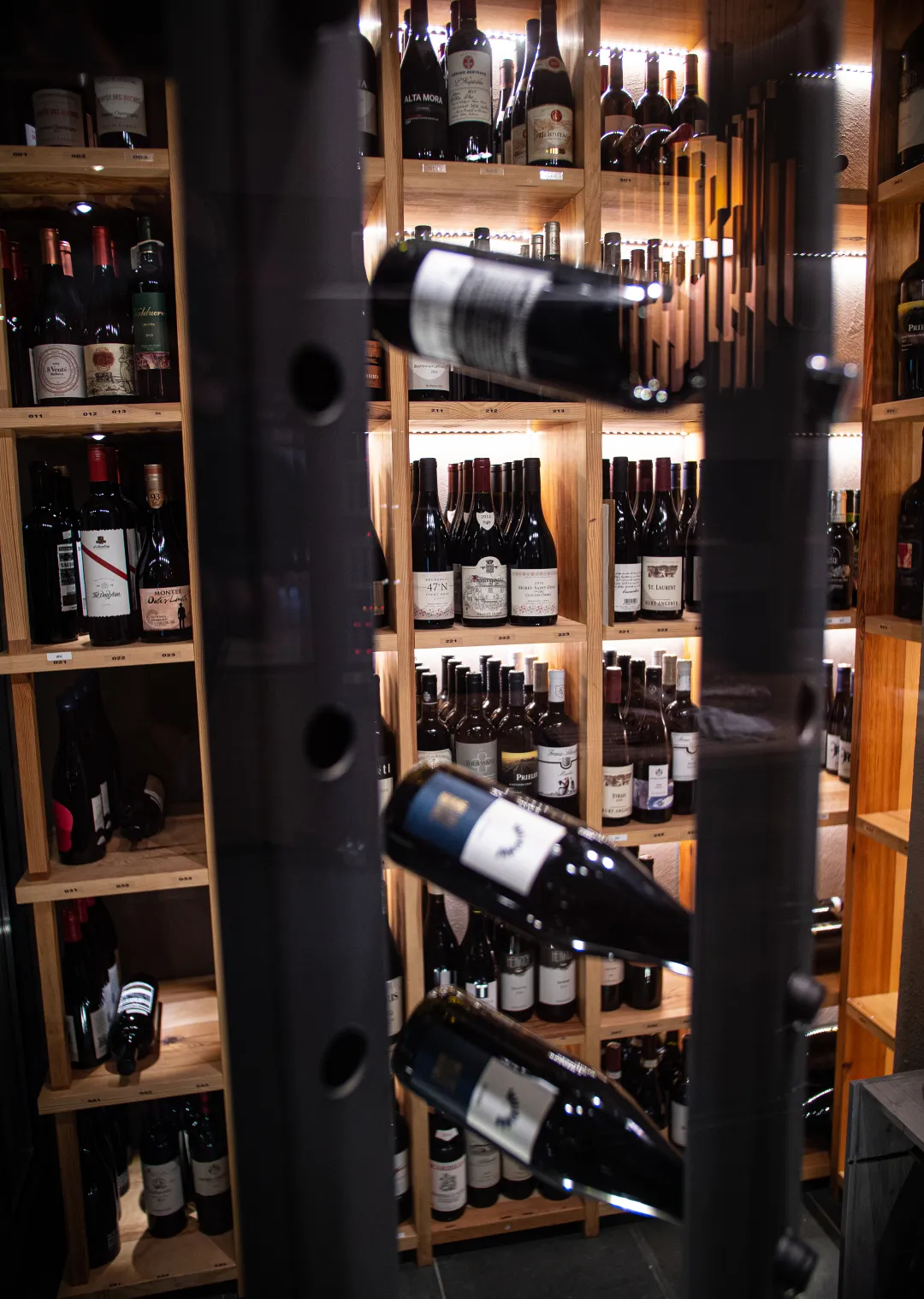 Weinregal mit Flaschen im Hintergrund