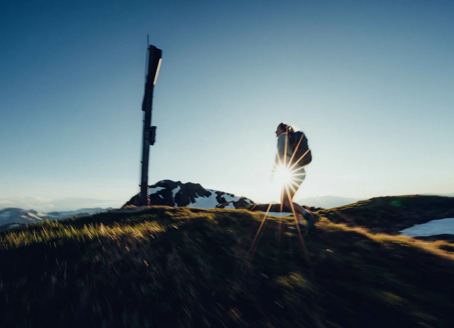 Wanderer mit Sonnenstrahlen in schneebedeckter Landschaft