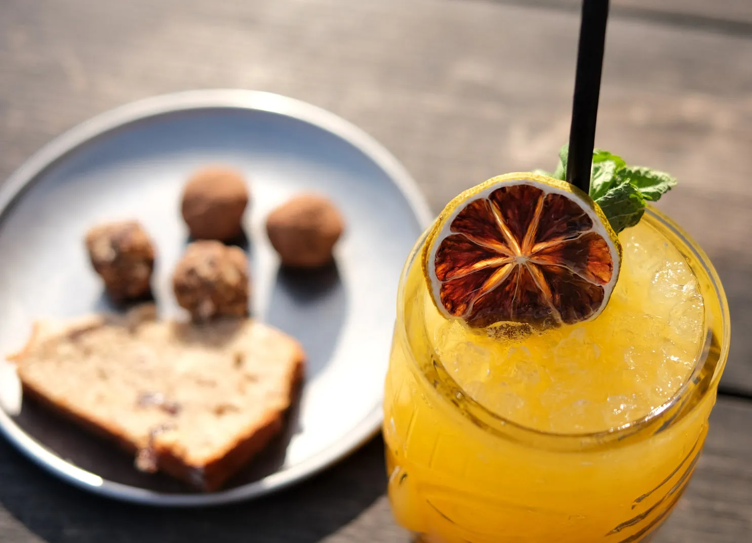 Cocktail mit getrockneten Früchten und Minze, Dessert im Hintergrund