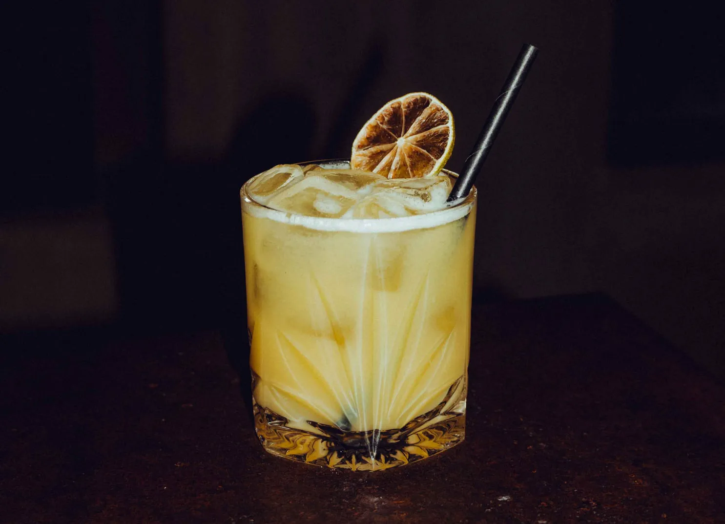 Cocktail mit Zitronenscheibe und Strohhalm