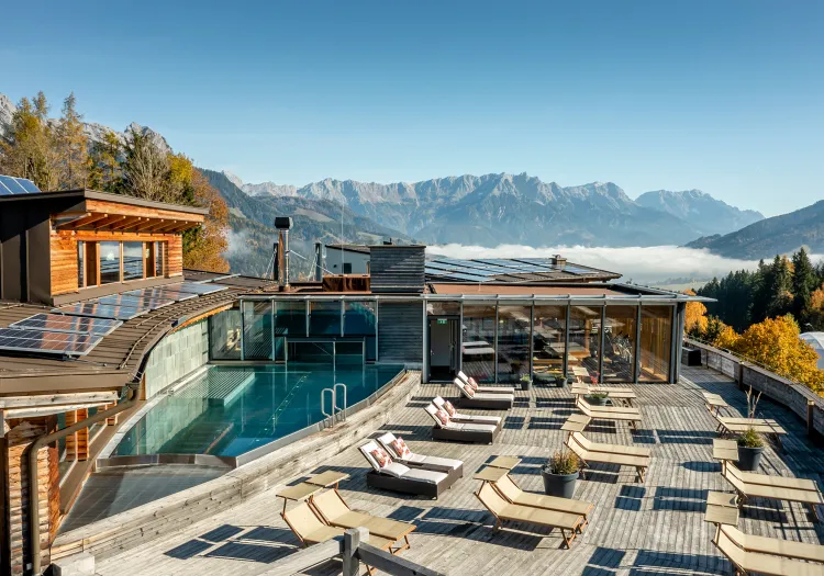 Moderne Architektur mit Pool und Liegen in den Bergen.